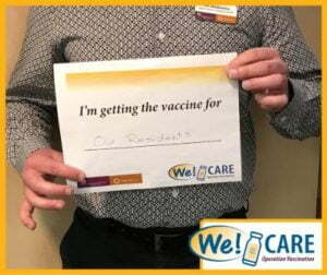 Team member holding up vaccine certificate