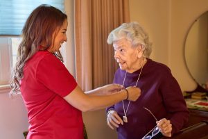 client with caregiver helping with pendant landscape