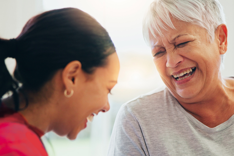 rhythms home care client and caregiver laughing together