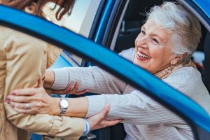 rhythms home care tips for caregiver helping client out of a car