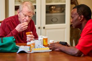rhythms home care senior man and caregiver with medications rhythms home care senior man and caregiver with medications