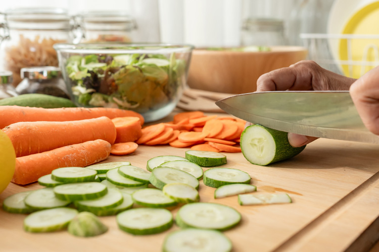 rhythms home care close up of hand cutting vegetables rhythms home care close up of hand cutting vegetables
