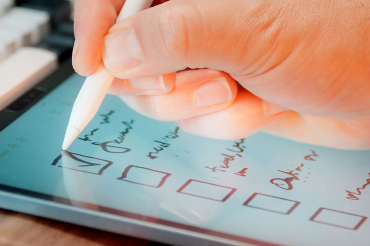 rhythms home care hand checking off boxes on ipad rhythms home care hand checking off boxes on ipad