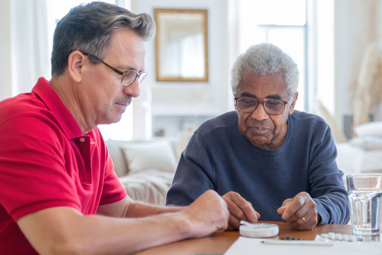 rhythms home care male caregiver assisting senior man with medicines rhythms home care male caregiver assisting senior man with medicines